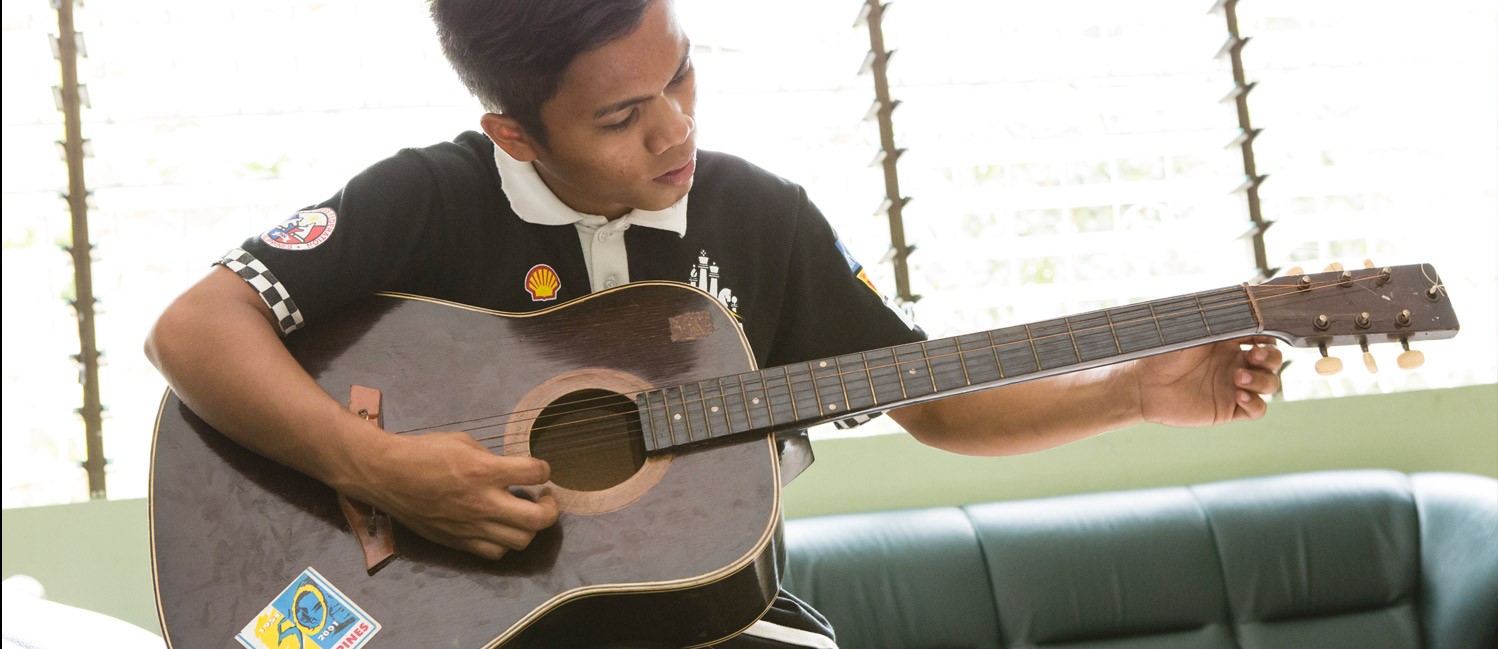 Ragazzo filippino che suona la chitarra